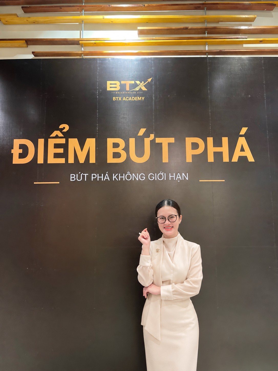 Linh Nguyễn đứng trước phông sự kiện